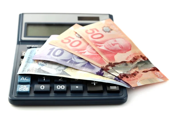 Калькулятор и канадские доллары, изолированные на белом — стоковое фото