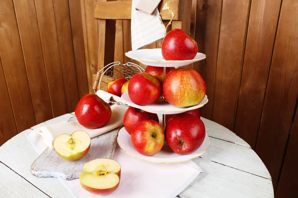 Läckra mogna äpplen på tjänstgör fack på tabellen på trä bakgrund — Stockfoto