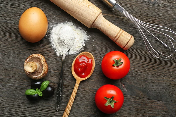 Ingredienser för matlagning pizza på träbord, ovanifrån — Stockfoto