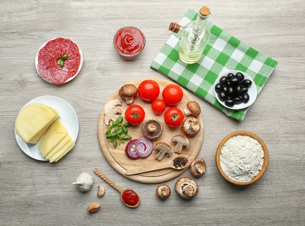 Ingredience na vaření pizza na dřevěný stůl, pohled shora — Stock fotografie