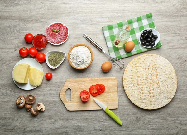 Ingredients for cooking pizza on wooden table, top view