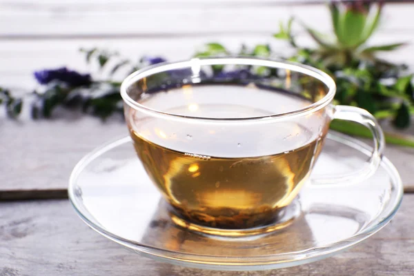 Cup of herbal tea with flowers on wooden table, closeup — Stock Photo, Image