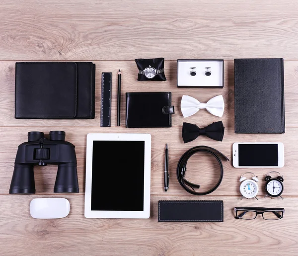 Set of black and white accessories on wooden table, top view