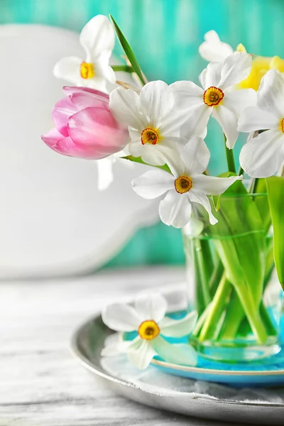 Ramo de primavera en taza de vidrio sobre fondo de madera de color —  Fotos de Stock