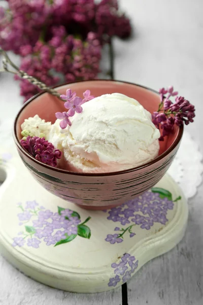 Beautiful composition with tasty ice cream and lilac flowers — Stock Photo, Image