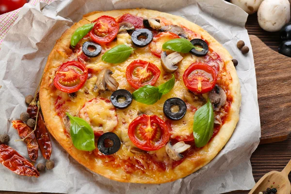 Sabrosa pizza con verduras y albahaca en la mesa de cerca —  Fotos de Stock