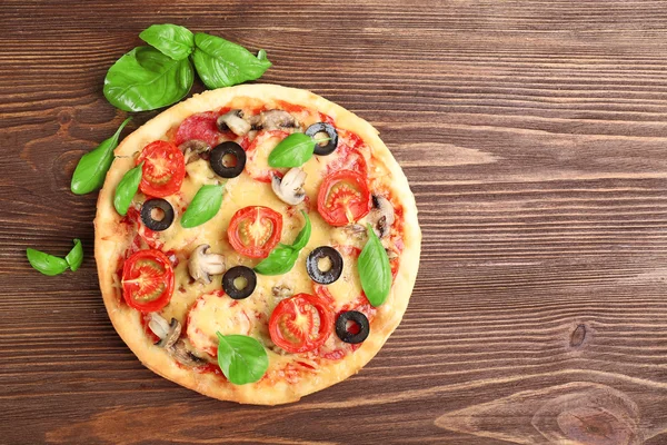 Gustosa pizza con verdure e basilico su fondo di legno — Foto Stock