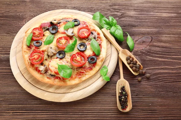 Sebze ve fesleğen ahşap arka plan üzerinde lezzetli pizza — Stok fotoğraf