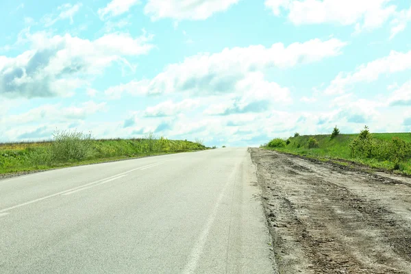 Landweg op blauwe hemelachtergrond — Stockfoto