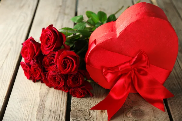 Valentýna dárkové krabice s červenými růžemi na starý dřevěný stůl ve tvaru srdce — Stock fotografie
