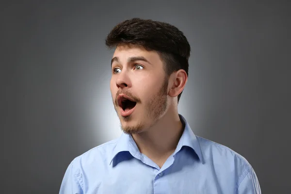 Porträt eines überraschten Mannes auf grauem Hintergrund — Stockfoto