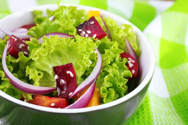 Tigela de salada verde fresca na mesa com guardanapo, close-up — Fotografia de Stock