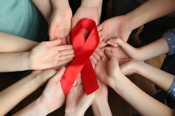 Group of female hands with red ribbon as breast cancer awareness symbol, closeup — Stock Photo, Image