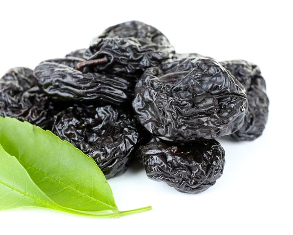 Pile of prunes with green leaves isolated on white — Stock Photo, Image