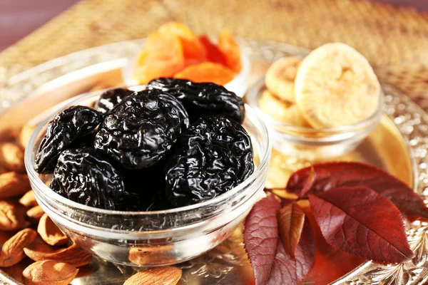 Ciruelas pasas y otras frutas secas en vaso con platillos de hojas de uva, primer plano —  Fotos de Stock