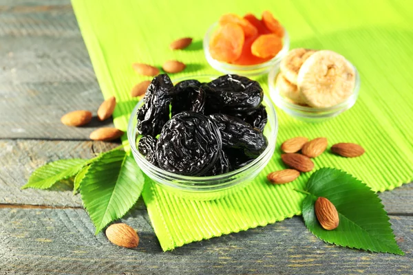 Dried fruits and almonds with leaves on green napkin, closeup — Stock Photo, Image