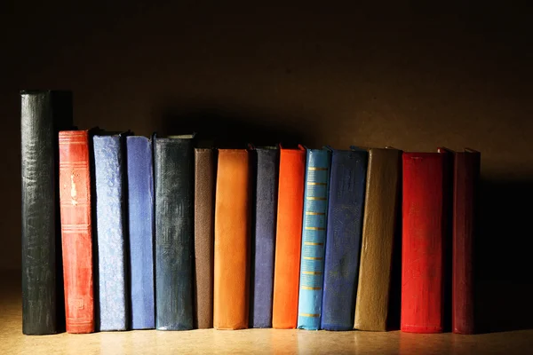 Libros antiguos en estante, primer plano, sobre fondo de madera oscura — Foto de Stock