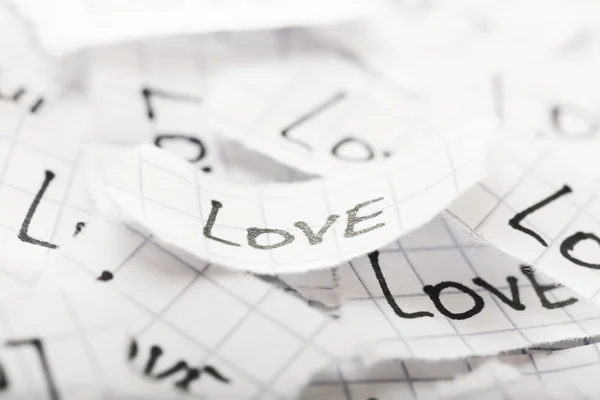 Words LOVE written on torn paper, closeup — Stock Photo, Image