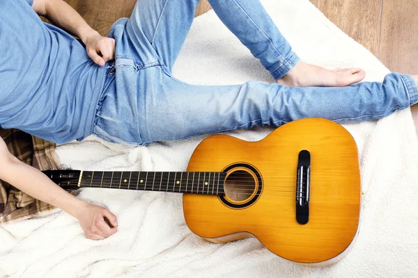 방 안에 기타를 가지고 있는 젊은이 — 스톡 사진