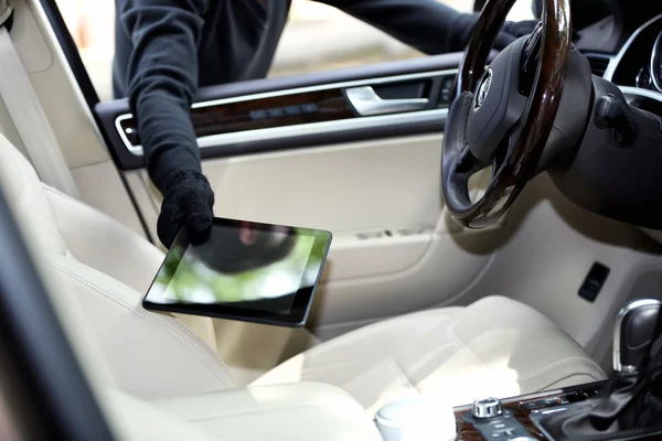 Homem ladrão rouba o tablet do carro — Fotografia de Stock