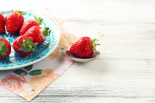 Erdbeeren auf Farbteller, auf Farbholzhintergrund — Stockfoto