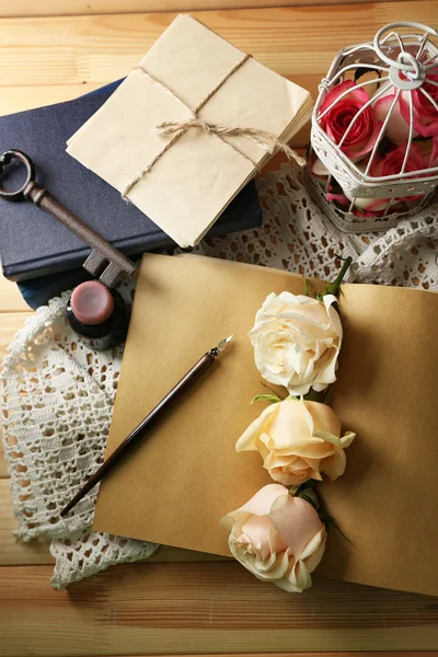 Färska rosor med gammal bok, nyckel och bokstäver på träbord bakgrund. Vintage koncept — Stockfoto
