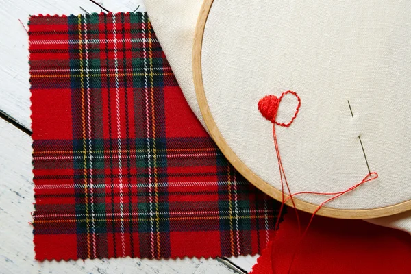 El aro de bordado con tela e hilos de coser rojos en la mesa de cerca — Foto de Stock