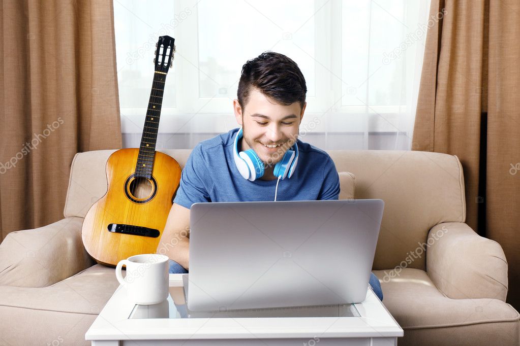 Young man using laptop in room