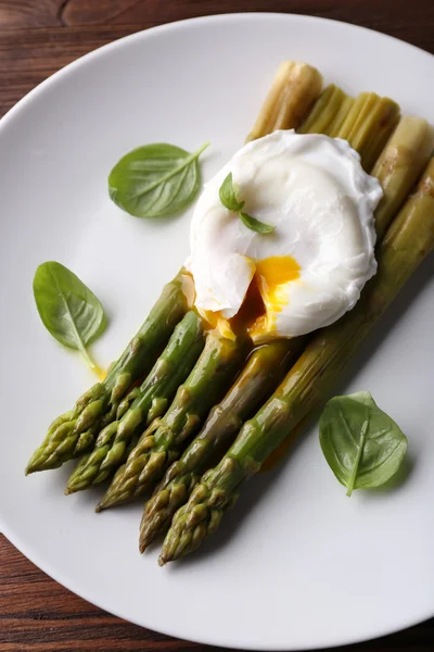 Roasted asparagus with poached egg on plate on table close up — Stock Photo, Image