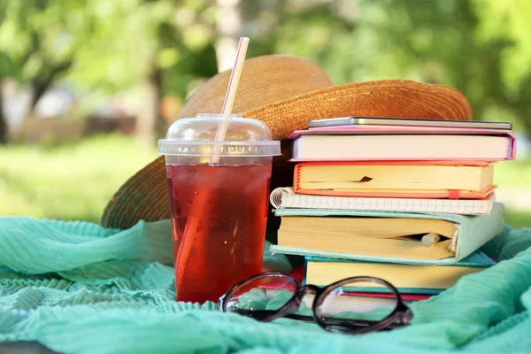 Könyvek, szemüveg, kalap, és inni a szabadban — Stock Fotó