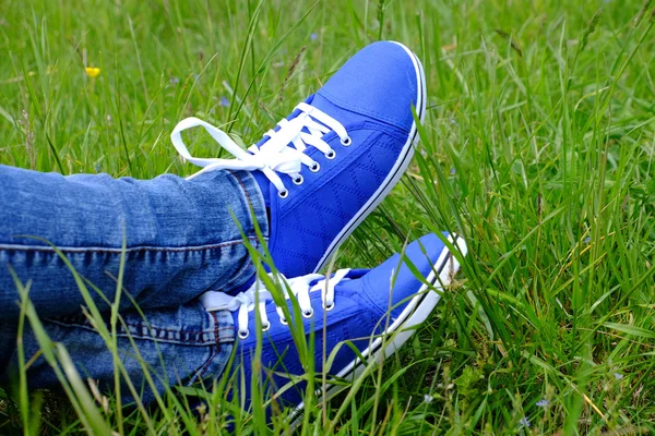 Pies femeninos en zapatos de goma sobre fondo de hierba verde — Foto de Stock