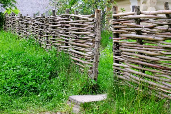 Плетеный деревенский забор в саду на фоне травы — стоковое фото
