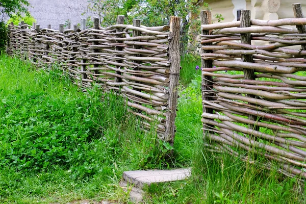 Clôture rustique en osier dans le jardin sur fond d'herbe — Photo