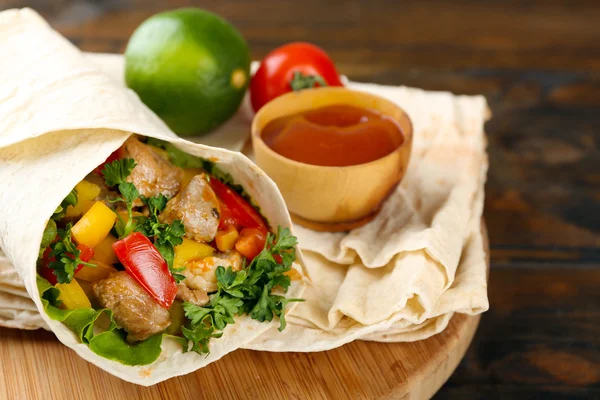 Hemgjord Mumsiga burrito med grönsaker på skärbräda, på trä bakgrund — Stockfoto