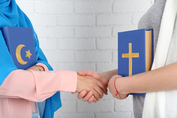 Due amici che tengono libri con simboli religiosi — Foto Stock