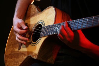 man playing on acoustic  guitar