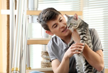 yakışıklı delikanlı ile evde basamaklarında oturan sevimli kedi