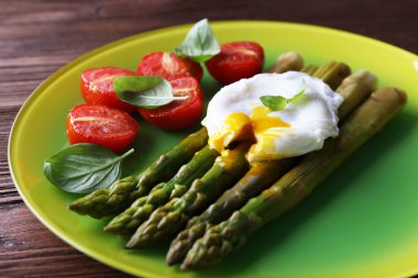 kavrulmuş kuşkonmaz masada tabağa haşlanmış yumurta ve domates ile yakın çekim