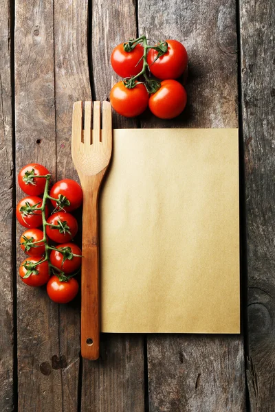 Folha de papel com tomate cereja em fundo de superfície de madeira rústica — Fotografia de Stock