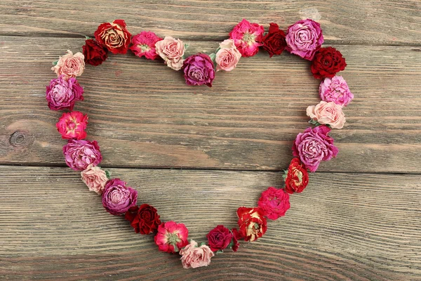 Dried flowers in shape of heart on wooden background — Stock Photo, Image