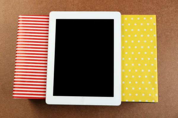 Notebook on top of pile of books and magazines on wooden background — Stock Photo, Image