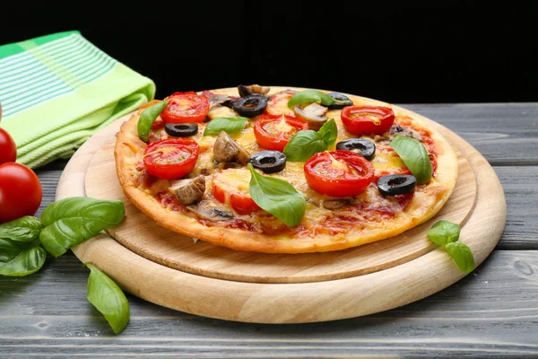 黒い背景にバジルと野菜のおいしいピザ — ストック写真