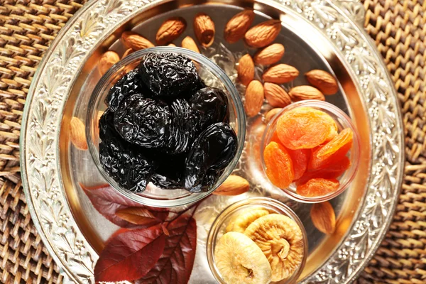 Ciruelas pasas y otras frutas secas en vaso con platillos de hojas de uva, primer plano —  Fotos de Stock