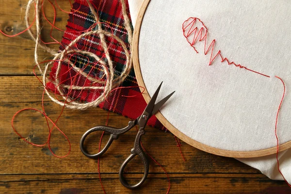 Обручка з вишивкою з полотном і червоними швейними нитками — стокове фото