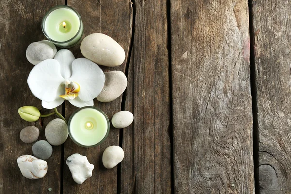 Still life with beautiful blooming orchid flower, spa treatment and pebbles, on wooden background Royalty Free Stock Photos