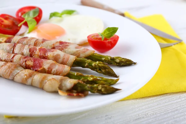 Plato de espárragos con tocino y huevo en plato sobre mesa, primer plano — Foto de Stock