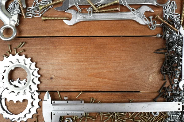 Tornillos y llaves bastidor, sobre fondo de madera — Foto de Stock