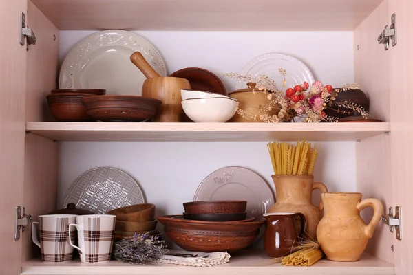 Utensílios de cozinha e utensílios de mesa em prateleiras de madeira — Fotografia de Stock