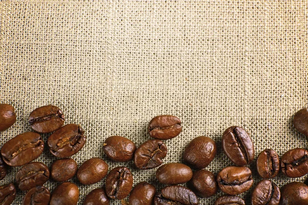 Frame van koffie bonen op zak achtergrondkleur — Stockfoto