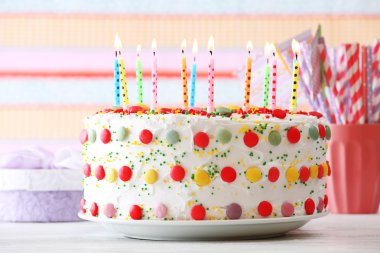 Doğum günü pastası ile mum renkli çizgili arka plan üzerinde